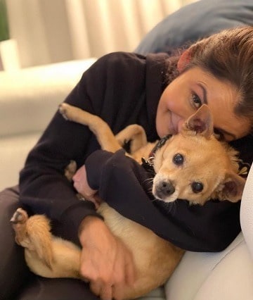 Picture of Anjali Bhimani in black dress playing with her dog Charly